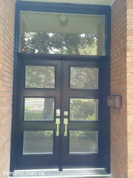 Double black front exterior doors installation. Modern shaker style door. Acid etched privacy glass. Oversized transom. High Dorothy retro collection shaker style